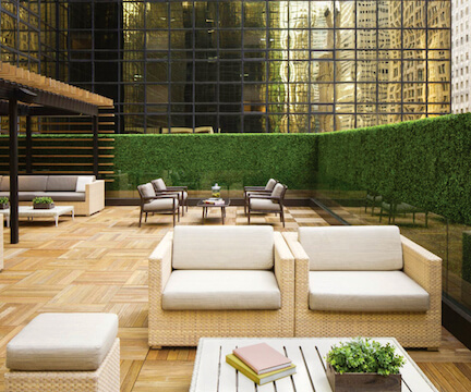 Outdoor patio with modern furniture and a lush green living wall.